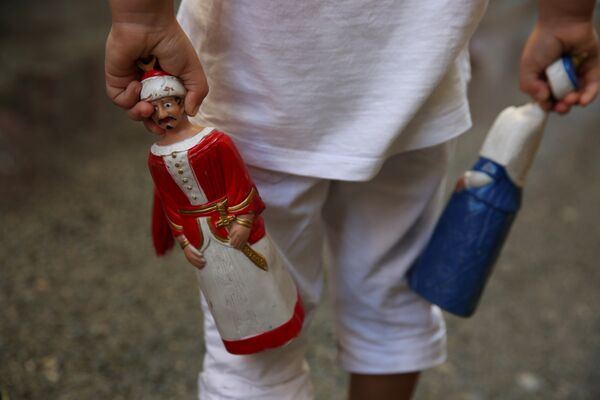Мальчик держит статуэтки гигантов во время фестиваля Сен-Фермин в Памплоне