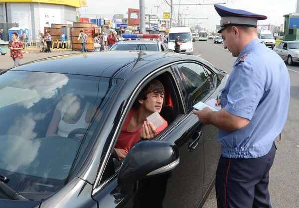 Сотрудник ГБДД проверяет документы у автовладельца Сотрудник ГБДД проверяет документы у автовладельца