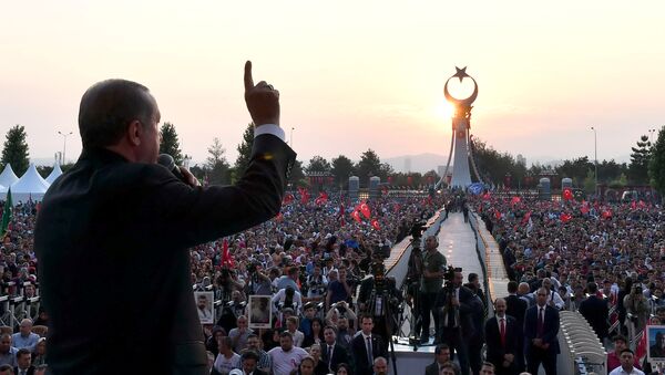 Президент Турции Тайип Эрдоган во время обращения к своим сторонникам на фоне памятника жертвам попытки военного переворота. 16 июля 2017