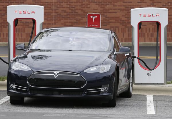 Автомобиль Tesla во время зарядки Автомобиль Tesla во время зарядки
