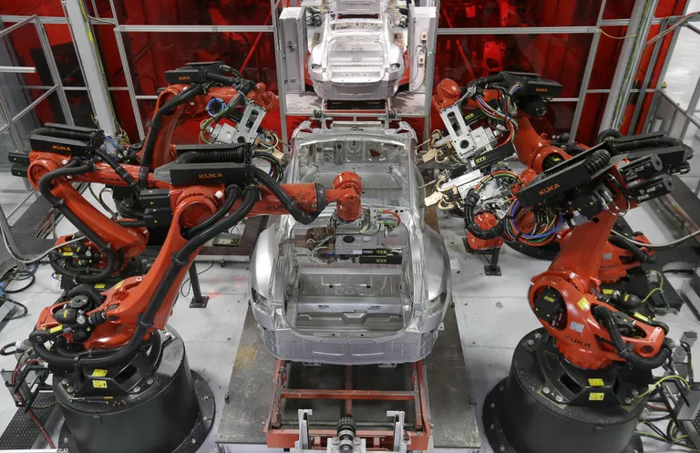 Сборка автомобилей Tesla роботами на заводе в Фремонте, Калифорния Сборка автомобилей Tesla роботами на заводе в Фремонте, Калифорния