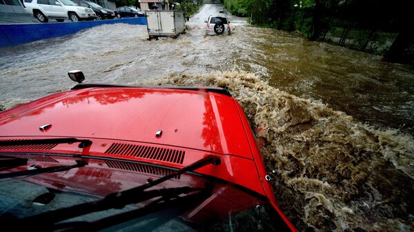 Автомобили на подтопленной проливными дождями улице. Архивное фото