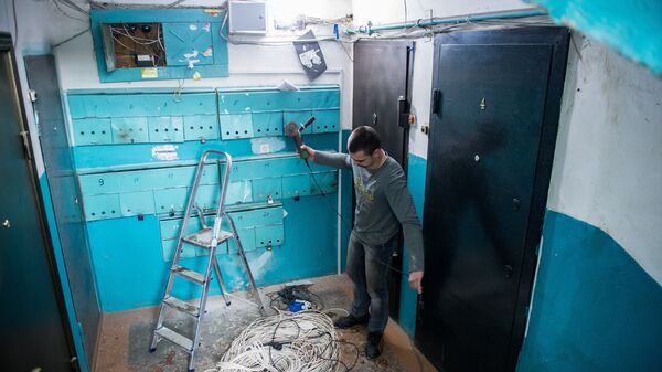 Рабочие регионального фонда капитального ремонта многоквартирных домов меняют электропроводку в подъезде жилого дома в Омске