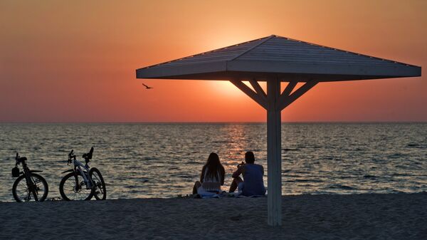 Отдыхающие на пляже на берегу Черного моря в поселке Оленевка на мысе Тарханкут в Крыму