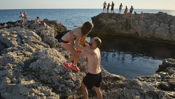Отдыхающие у природного бассейна Чаша любви на мысе Тарханкут в Крыму