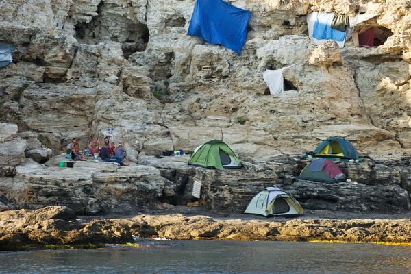 Туристы на берегу Черного моря вблизи Большого Атлеша на мысе Тарханкут в Крыму