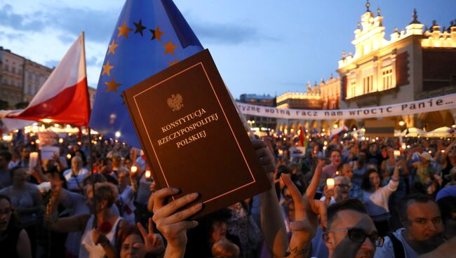 Копия Конституции Польши в руках демонстранта во время акции протестов против законодательной реформы Верховного суда на главной площади в Кракове. 22 июля 2017