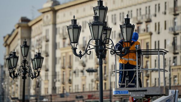 Сотрудник ЖКХ красит фонари в Москве. Архивное фото