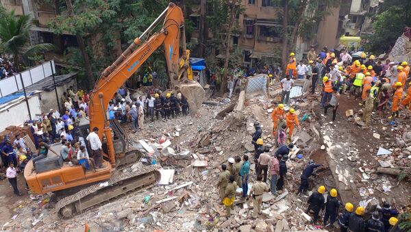Спасатели на месте обрушения жилого дома в пригороде Мумбаи, Индия. 25 июля 2017