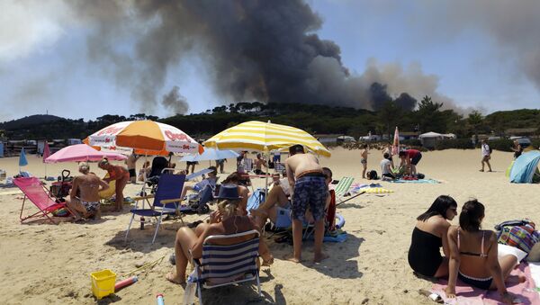 Вид на лесные пожары с пляжа  Ле-Лаванду в регионе Лазурный берег во Франции. 26 июля 2017