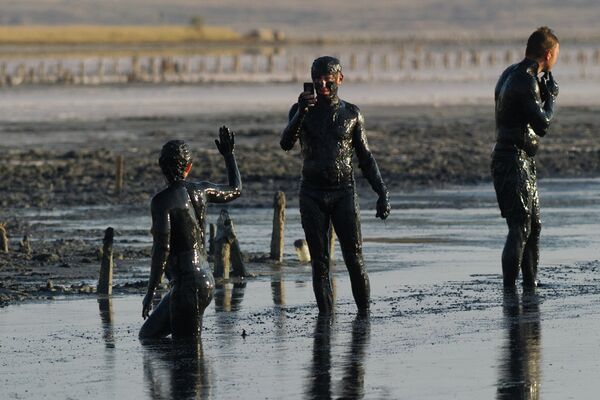 Отдыхающие принимают грязевые ванны на Чокракском озере в Крыму
