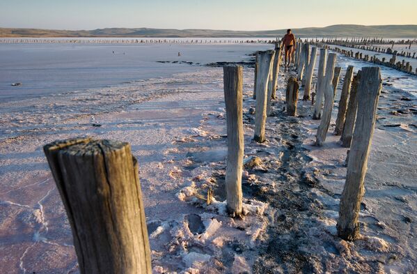 Отдыхающие набирают розовую соль на Чокракском озере в Крыму