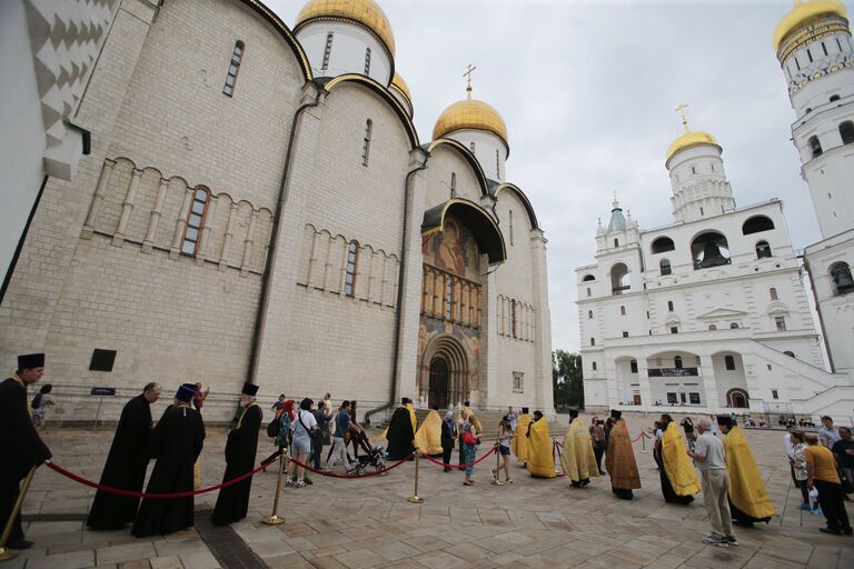 Туристы и священнослужители на Соборной площади Московского Кремля перед началом крестного хода в Москве к памятнику князя Владимира в День крещения Руси