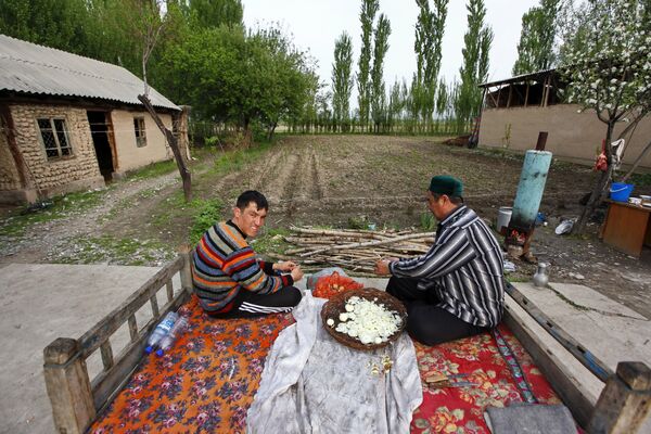 Жители села Тейит чистят лук во дворе своего дома