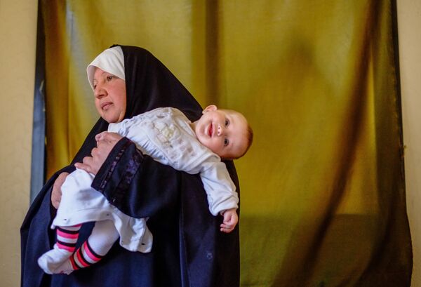 Женщина с ребенком — беженцы из Сирии — в одном из домов в городе Хальба на севере Ливана