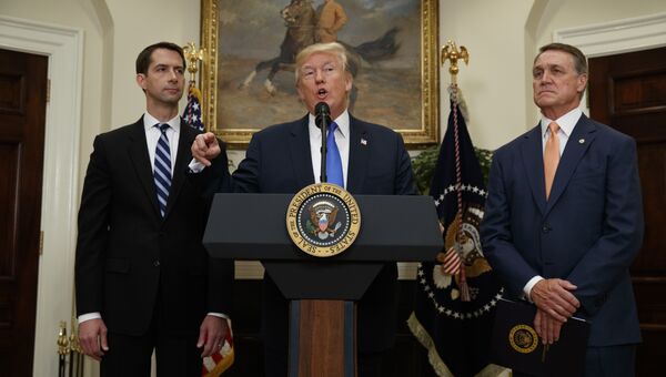 Президент США Дональд Трамп в окружении сенатора Тома Коттона и сенатора Дэвида Перду в Белом доме в Вашингтоне. 2 августа 2017