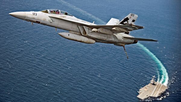 Самолет F/A-18F Super Hornet пролетает над авианосцем USS Gerald R. Ford в Атлантическом океане
