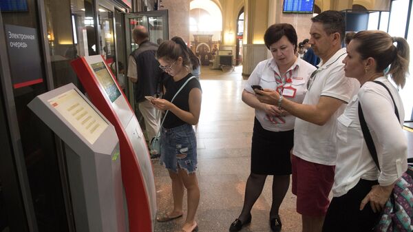 Пассажиры получают билеты в электронную очередь на Ленинградском вокзале. 3 августа 2017