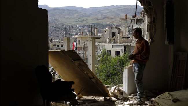 Мужчина смотрит на руины в окрестностях Дамаска после  авиаударов коалиции во главе с США по позициям ИГИЛ. Архивное фото