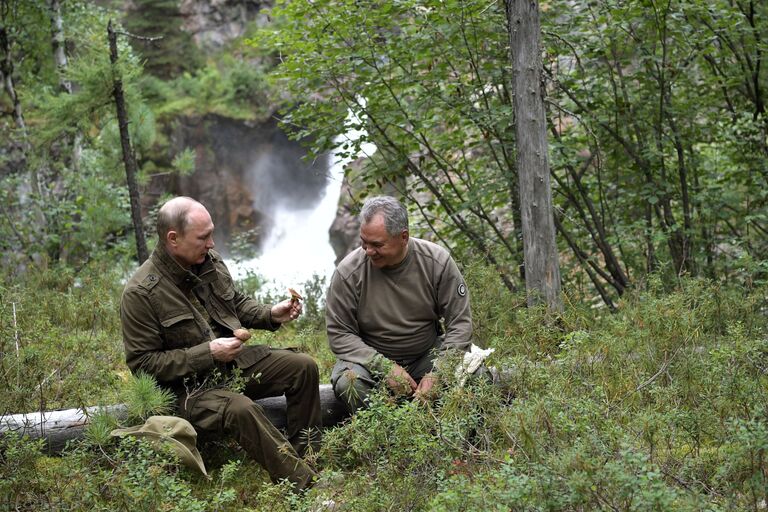 Президент РФ Владимир Путин и министр обороны РФ Сергей Шойгу во время похода по горам в Республике Тыва