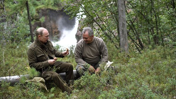 Президент РФ Владимир Путин и министр обороны РФ Сергей Шойгу во время похода по горам в Республике Тыва