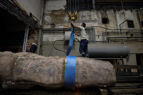 Рабочий закрепляет элементы конструкции монумента Стена скорби перед началом его транспортировки к месту установки в Москве