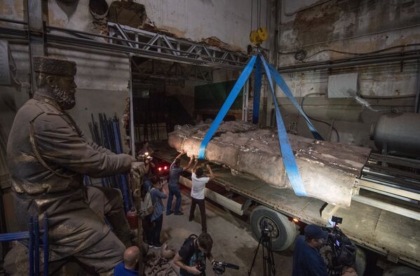 Рабочие закрепляют элементы конструкции монумента Стена скорби перед началом его транспортировки к месту установки в Москве