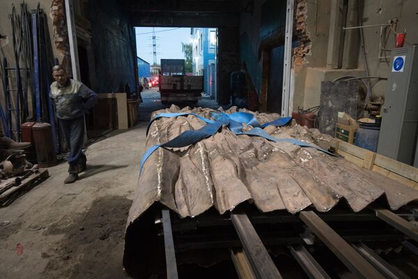 Рабочие готовятся закрепить элементы конструкции монумента Стена скорби перед началом его транспортировки к месту установки в Москве