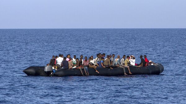 Мигранты около ливийского побережья ждут спасения итальянской береговой охраны. 6 августа 2017