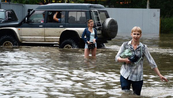 Жители на затопленной улице Уссурийска. 7 августа 2017