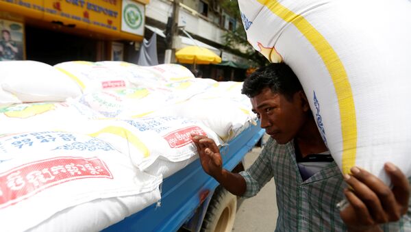 Мужчина грузит мешок риса в городе Пномпень, Камбоджа. 12 июля 2017
