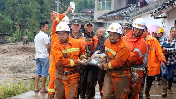 Спасатели транспортируют пострадавшего при сходе селя в провинции Сычуань в Китае. 8 августа 2017
