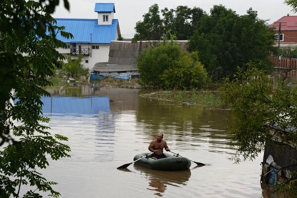 Мужчина на лодке во время наводнения в Уссурийске
