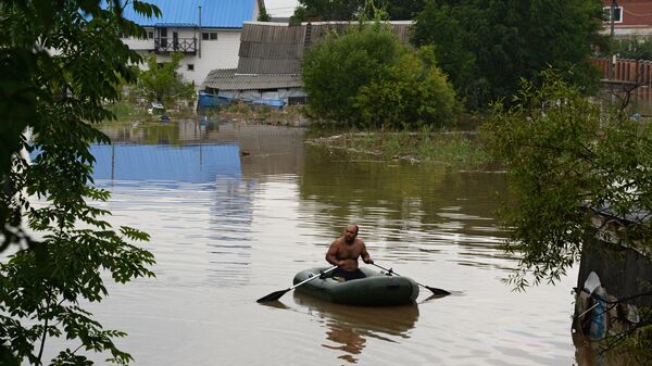 Мужчина на лодке во время наводнения в Уссурийске. Архивное фото