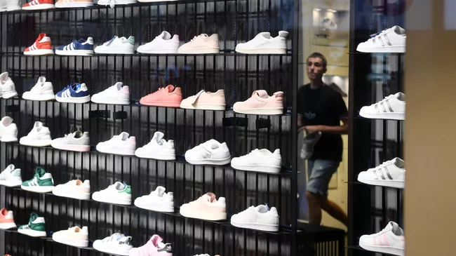 Стеллаж с кроссовками в одном из магазинов спортивной одежды и обуви Adidas Стеллаж с кроссовками в одном из магазинов спортивной одежды и обуви Adidas