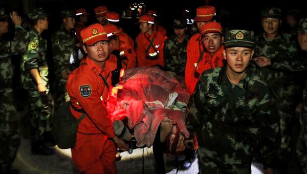 Военная полиция эвакуирует постадавших в районе землетрясения в китайской провинции Сычуань