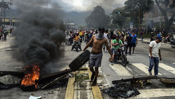 Антиправительственные активисты строят баррикаду в городе Венесуэлы, Валенсия. 6 августа 2017