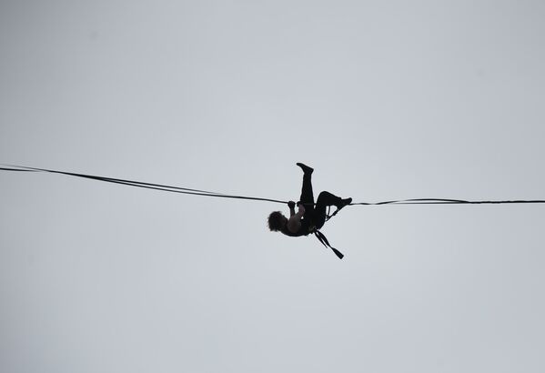 Канатоходец Максим Кагин во время прохода по стропе, натянутой на высоте 126 метров между двумя небоскребами жилого комплекса Чемпион Парк, в Екатеринбурге