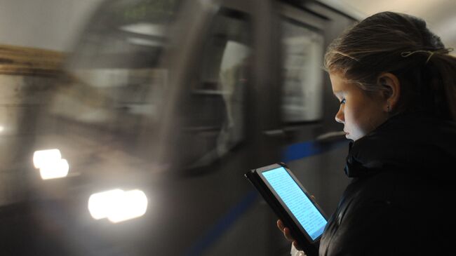 Пассажирка во время чтения электронной книги на станции метро