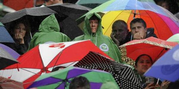 Зрителям оставалось только лишь стоять под зонтами и ждать, когда закончится дождь.
