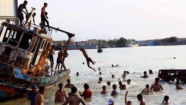 Местные жители купаются во время жары в пригороде Басры, Ирак. 29 июля 2017