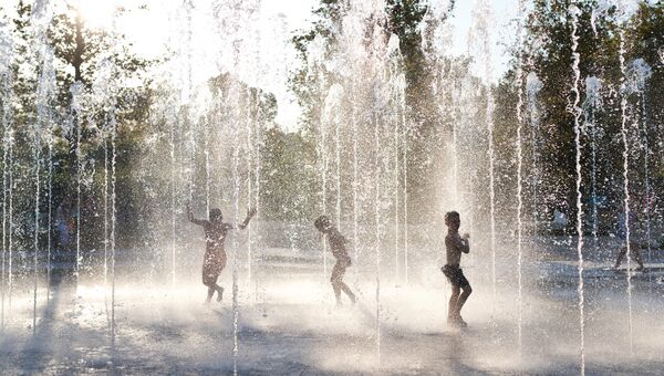 Дети купаются в фонтане в Афинах. 5 августа 2017
