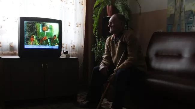 Пенсионер смотрит телевизор в Старорусском доме-интернате для престарелых и инвалидов Приильменье