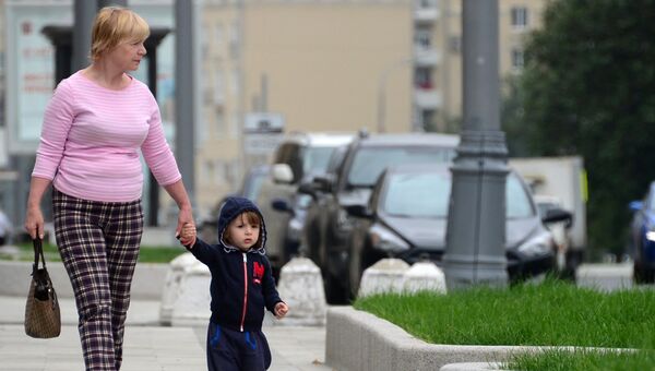 Женщина с ребенком идут по улице в Москве. Архивное фото