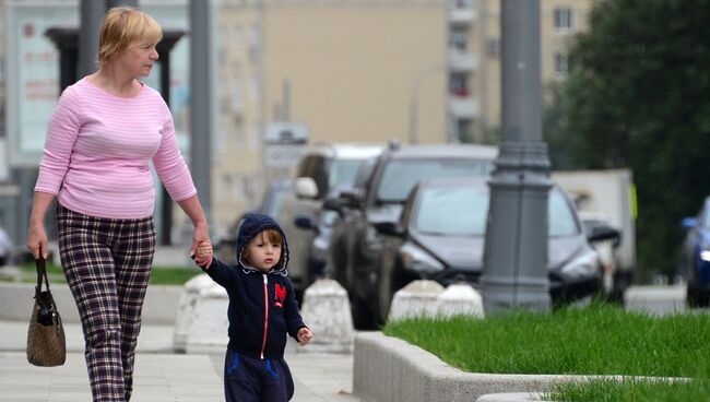 Женщина с ребенком идут по улице в Москве. Архивное фото