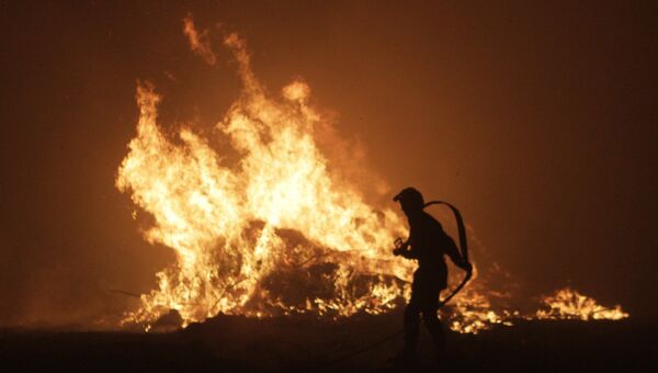 Пожарный борется с огнем на французском острове Корсика. 11 августа 2017
