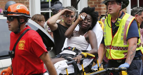 Спасатели оказывают женщине первую помощь после того, как автомобиль наехал на участников протестов в Шарлоттсвилле, штат Вирджиния