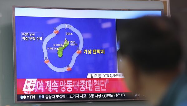 Мужчина смотрит новостную программу, в которой сообщается о планах Северной Кореи по запуску ракет в воды вблизи острова Гуам, в Южной Корее. 15 августа 2017 года