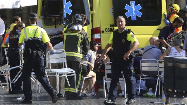 Скорая помощь оказывает помощь пострадавшим на месте наезда микроавтобуса на пешеходов в Барселоне. 17 августа 2017