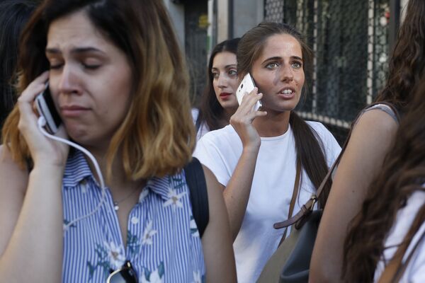 Люди звонят родственникам и друзьям после наезда микроавтобуса на пешеходов в Барселоне. 17 августа 2017